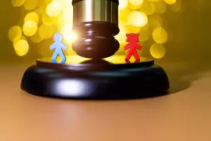 A gavel with two wooded dolls, representing Child Custody for a law firm in Peoria IL