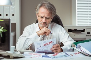 A man looking at overdue bills who may need Bankruptcy Attorneys in East Peoria IL