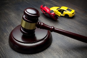 A gavel next to two crashed toy cars, representing an Auto Accidents Lawyer in Pekin IL