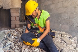 A worker in a construction accident, holding his knee and needing to speak with a Workers' Comp Attorney in Peoria IL