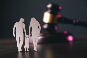 A paper cutout of a family in front of a gavel, representing Lawyers in Family Law for Peoria IL