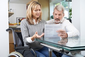 A woman in a wheelchair discussing paperwork with a Social Security Disability Lawyer in Peoria IL